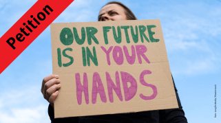 urgewald-Petition: Person mit Protestschild "Our Future Is In Your Hands"